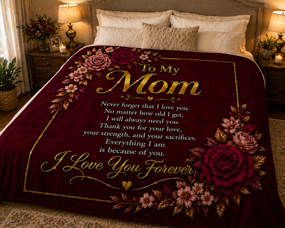 Floral-themed blanket with a message to 'My Mom' on a bed in a bedroom setting.